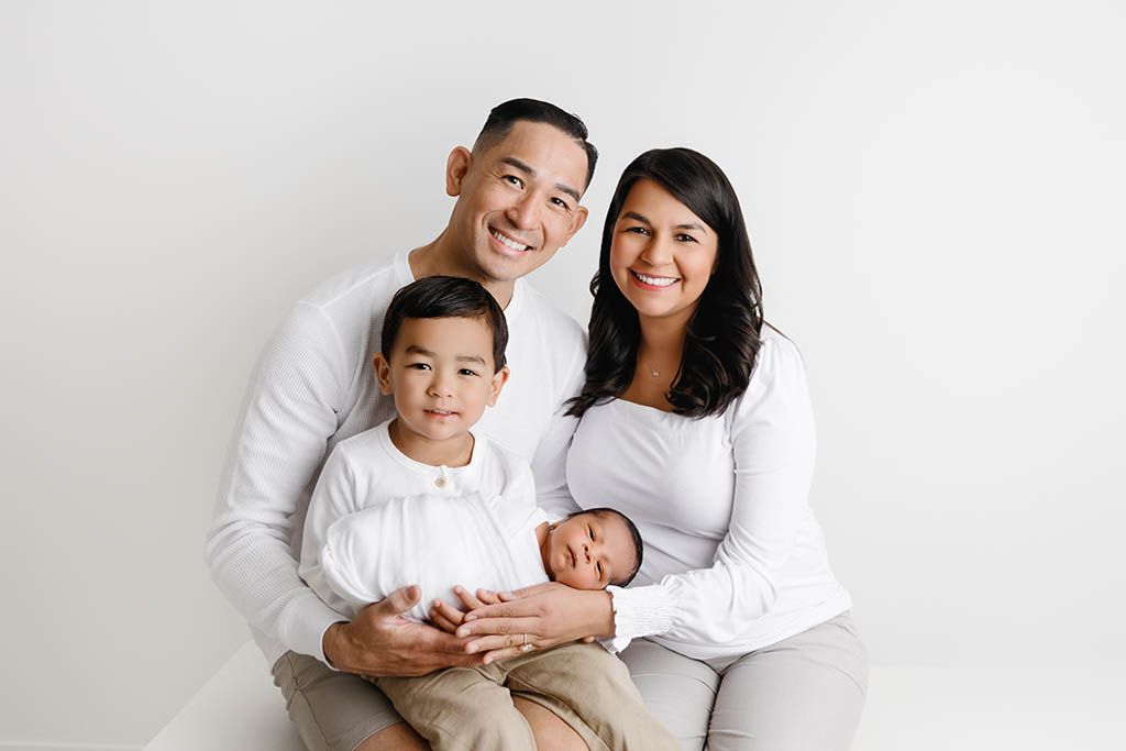 Family and newborn photographer near Murrieta CA -portrait of smiling parents with toddler and newborn boys.