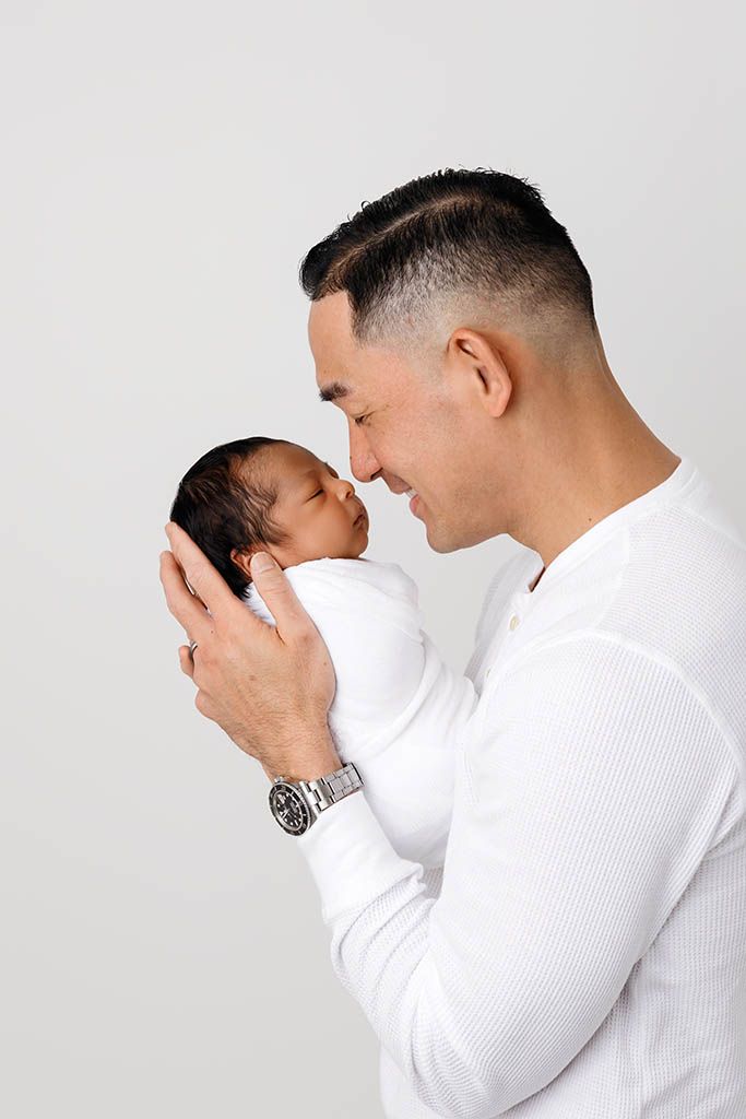 Father and newborn son in professional studio portrait by Murrieta newborn photographer.