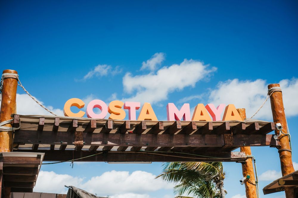 Colorful Costa Maya sign against a bright blue sky at a tropical port.