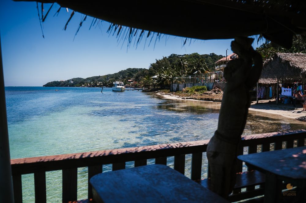 Scenic view of crystal clear turquoise Caribbean waters from a rustic thatched roof beach hut.