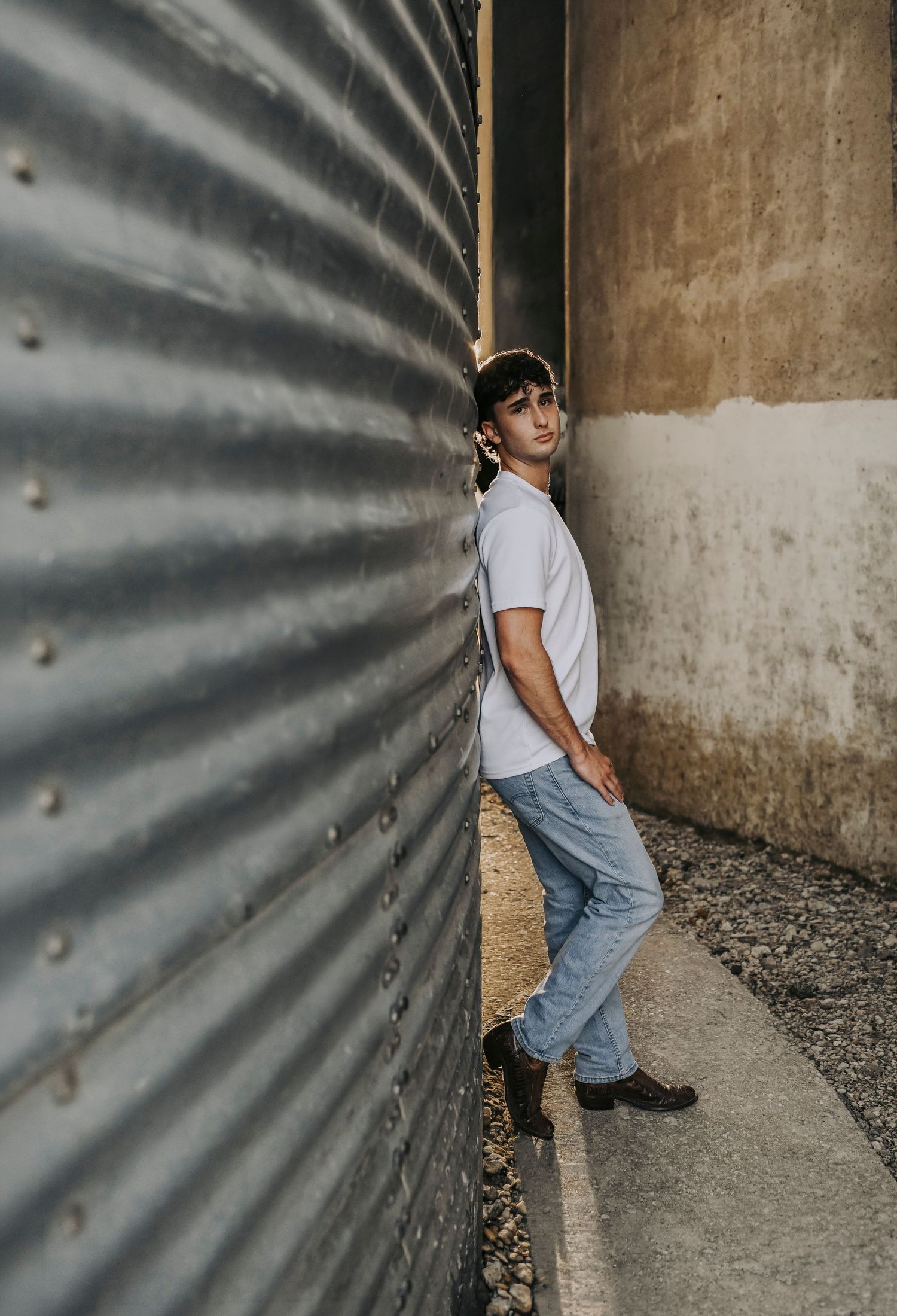 Senior guy leaning against textured alley wall in Historic Downtown McKinney