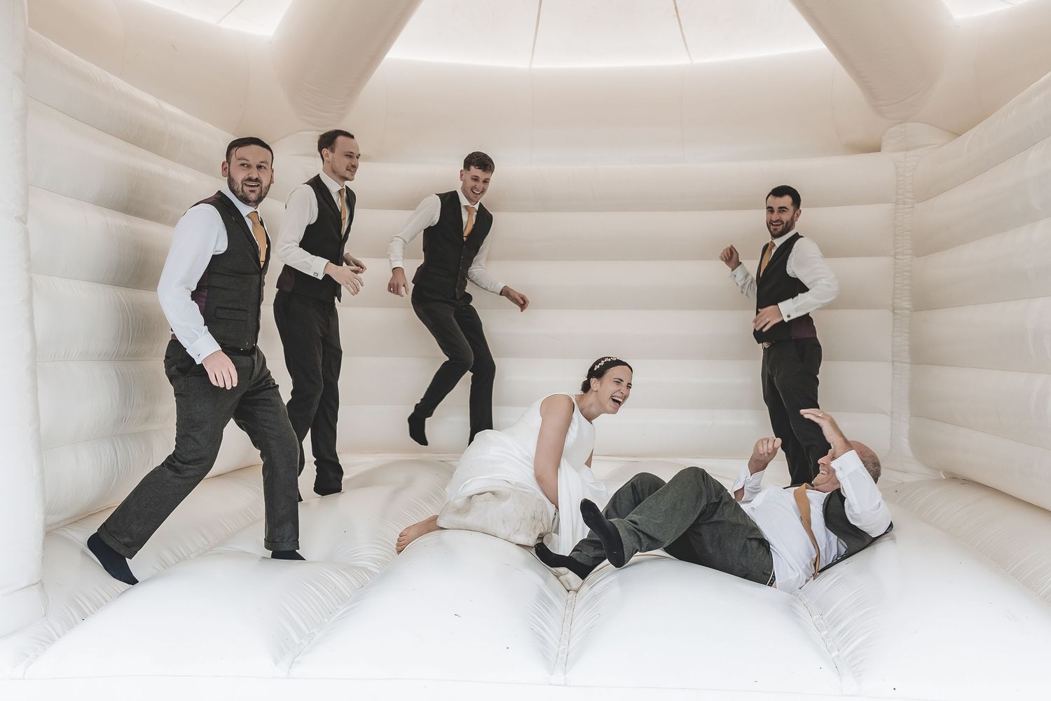 A fun rainy day wedding moment utilising the bouncy castle and having fun.