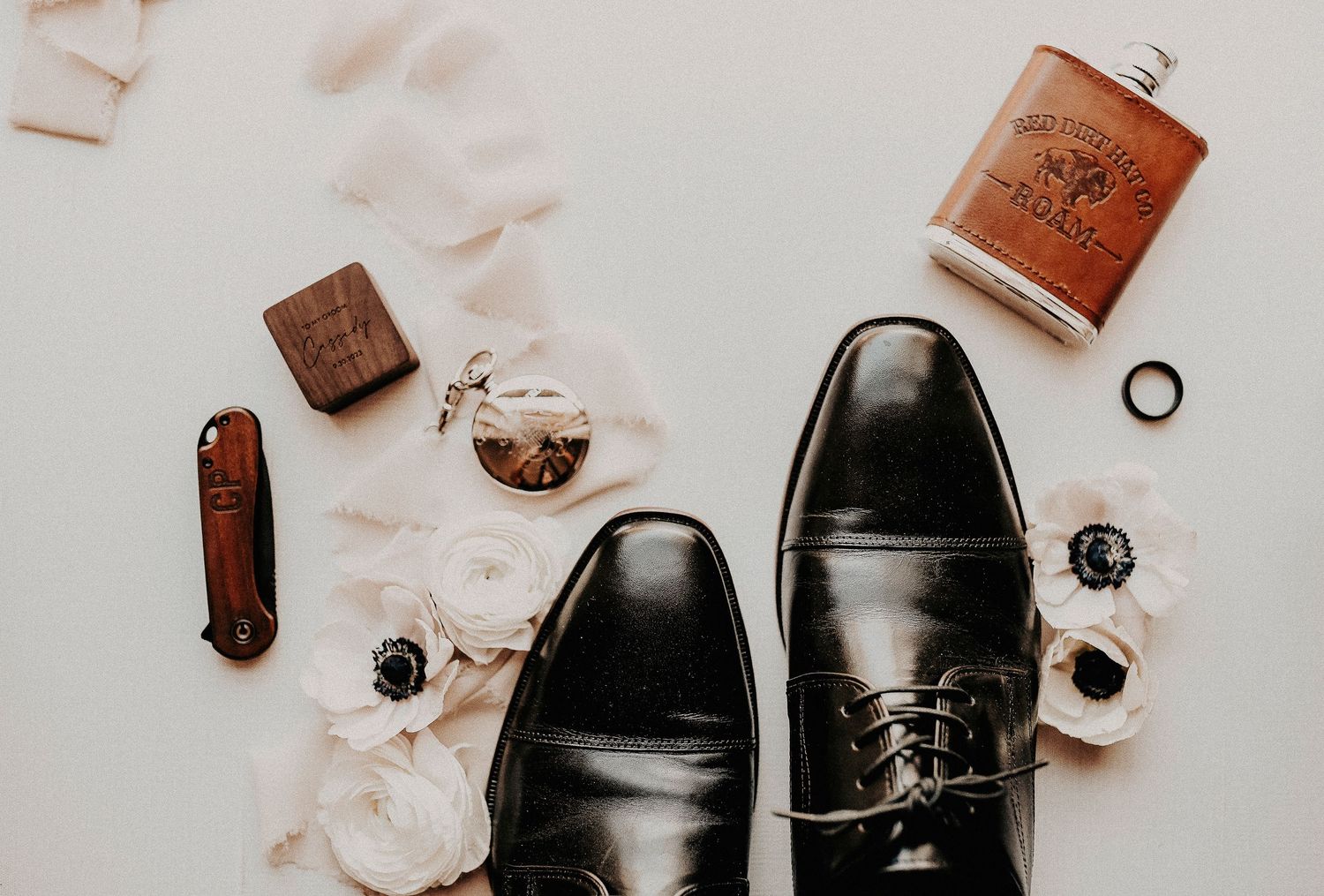 high-end wedding detail flat lay with designer perfume, bridal shoes, and soft ribbon accents