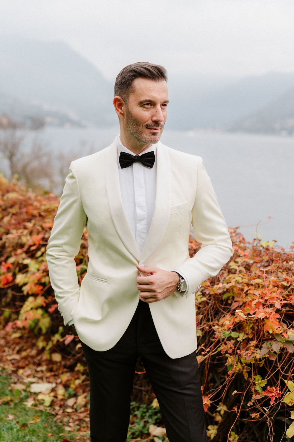 A formal white dinner jacket and black bow tie photographed against an autumn landscape with mountains in the background.