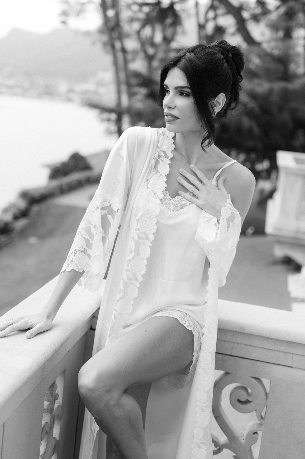 Black and white portrait series showing a person in a white ruffled blouse sitting on an outdoor balcony.
