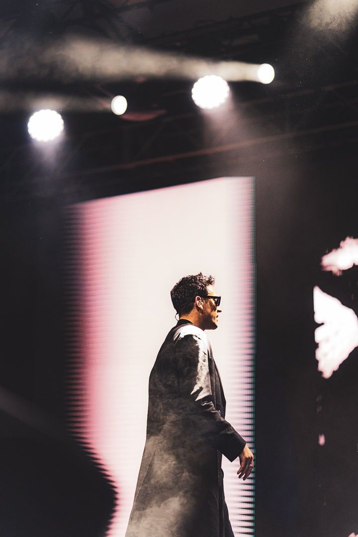 Dramatic side profile silhouette against a white screen with stage lighting.