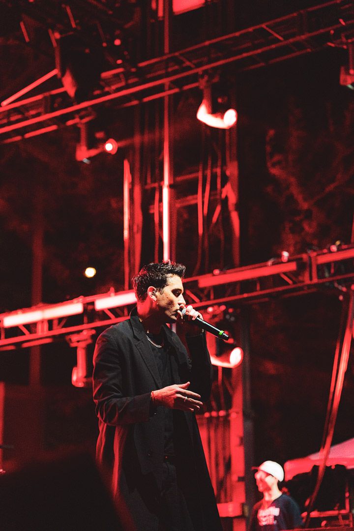 Dark silhouette of a performer on stage illuminated by intense red theatrical lighting.