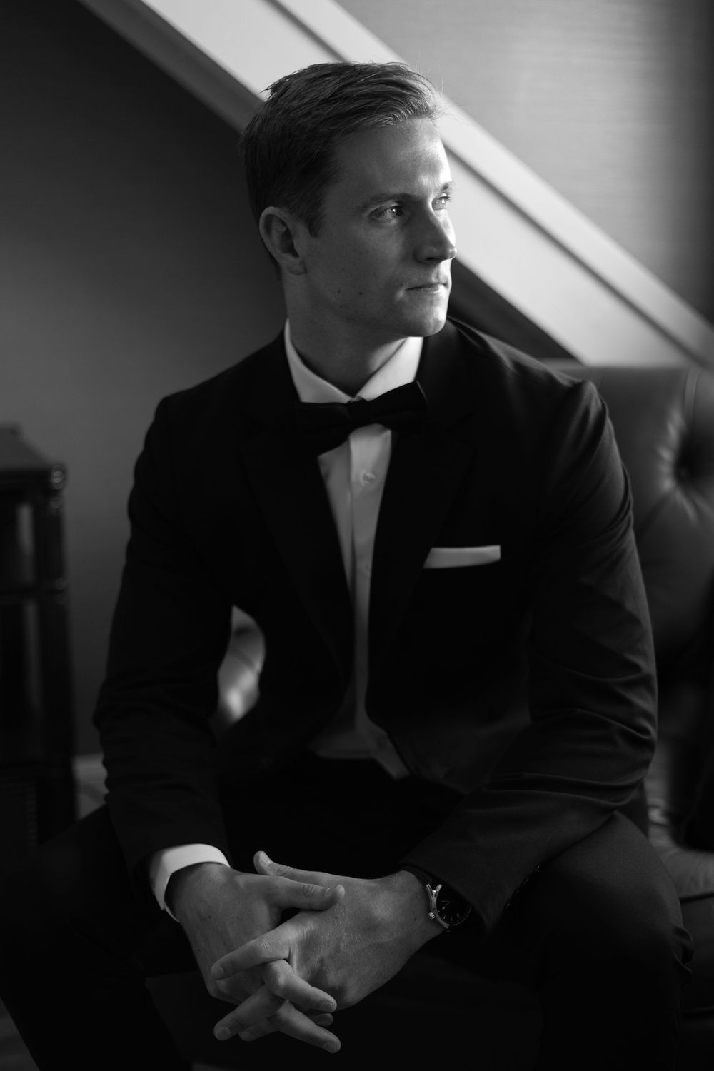 A black and white photo sequence showing a person in a suit sitting and looking away in dramatic lighting.