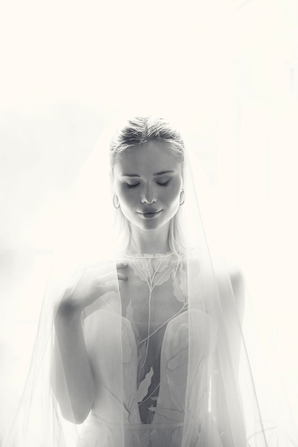 Ethereal black and white triptych portrait series showing figures draped in soft translucent veils creating a dreamy effect.