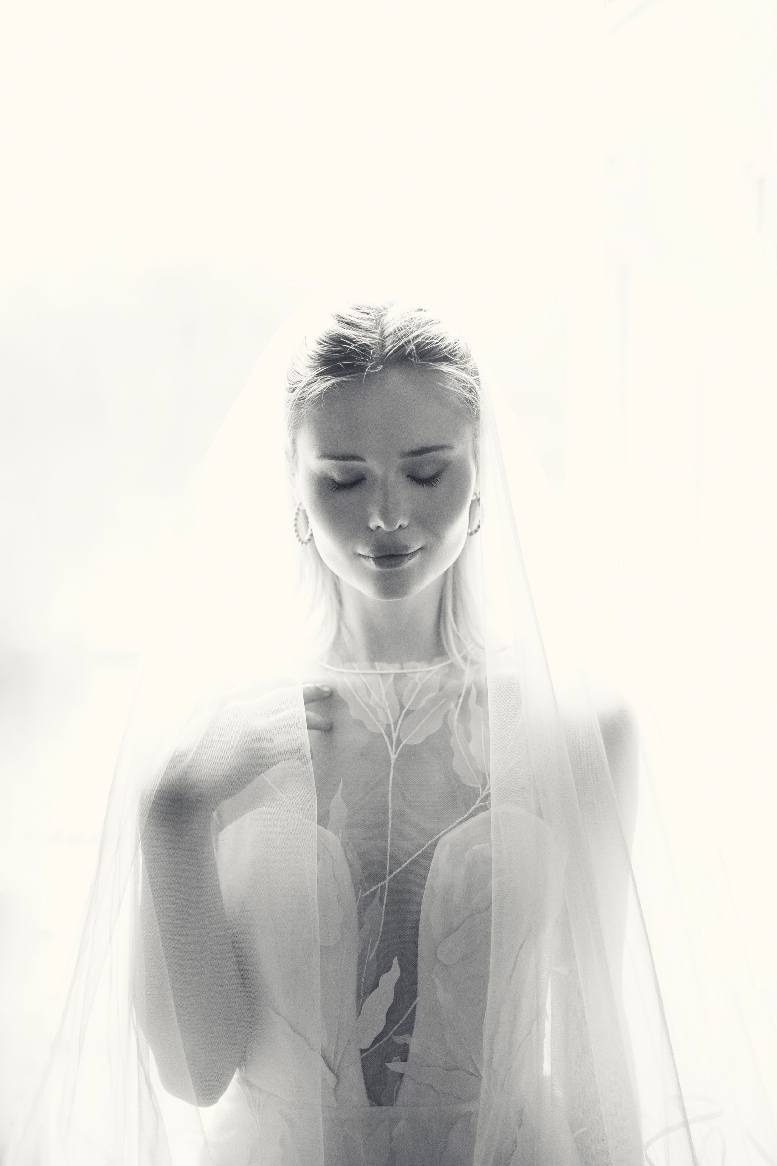 Ethereal black and white triptych portrait series showing figures draped in soft translucent veils creating a dreamy effect.