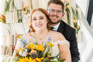 Wedding celebration with sunflower decorations in bright indoor setting.