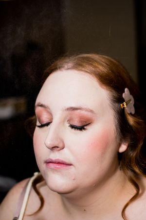 Close-up shot showing soft pink bridal makeup and closed eyes.
