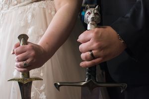 Close-up details of hands holding vintage items during wedding ceremony.