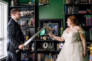Wedding couple interacting playfully in front of bookshelves and collectibles.
