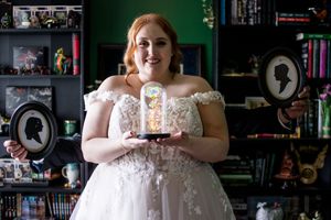 Wedding preparation moments captured in dark room with bookshelves.