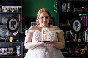 Bridal portrait against dark background with bookshelves showcasing vintage decor.