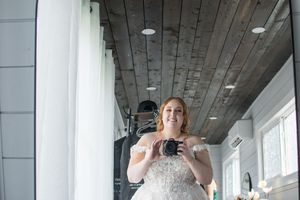 Interior of modern wedding venue with rustic wood ceiling and white walls.