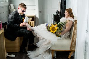 Wedding celebration at rustic venue with sunflower bouquets and white decor.