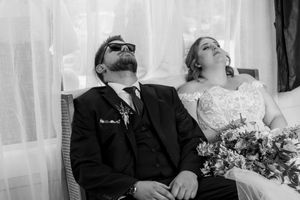Wedding party relaxing on outdoor furniture during reception.