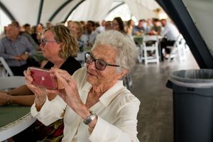 Wedding reception guests enjoying the celebration inside a covered venue space.
