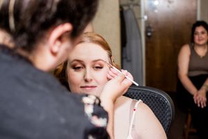 Final wedding preparation touches being applied in a quiet moment.