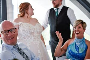 Wedding guests share joyful laughter during a celebration.