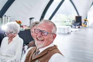 A group of senior citizens enjoying a social gathering and laughing together at a community event.