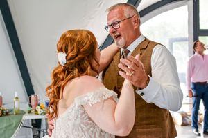 Joyful wedding celebration with guests in formal attire sharing emotional moments indoors.