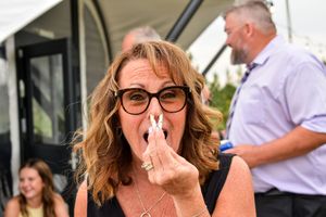 Wedding guests share emotional reactions and laughter during a reception celebration.