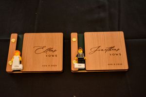 Two wooden vow books with engraved covers displayed side by side.