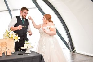 Couple cuts their wedding cake together during an elegant reception.