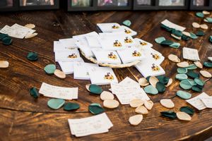 Wedding cards and teal confetti scattered across a dark wooden surface.
