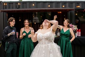 Wedding party in emerald green dresses and formal wear poses for group photos.