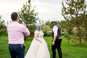 Wedding couple and guests walking through an outdoor venue with pine trees in the background.