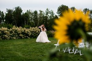 Wedding couple poses in meadow with yellow wildflowers in foreground.