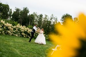Wedding photography in sunny garden with yellow flowers in foreground.