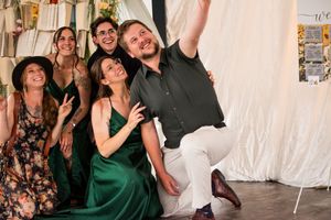 Group of wedding guests dancing and celebrating together on a dance floor at a reception party.
