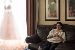 Wedding party members relaxing on a couch in formal attire during a reception.