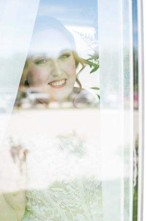 Soft focus artistic wedding photography through sheer white fabric.
