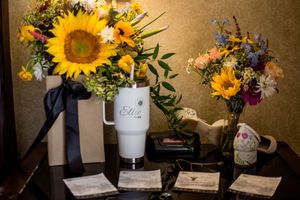Rustic floral arrangements with bright sunflowers and wildflowers in white vases.