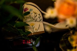 Colorful autumn flowers and decorative elements arranged on a dark background with soft bokeh lighting effects.