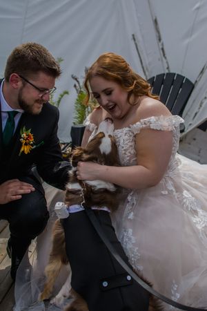 Couple sharing a joyful moment while seated in Adirondack chairs at their wedding.