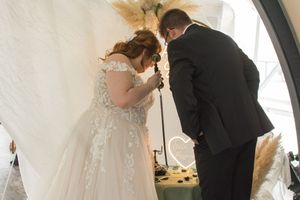 Intimate wedding moments captured under white fabric draped ceiling.