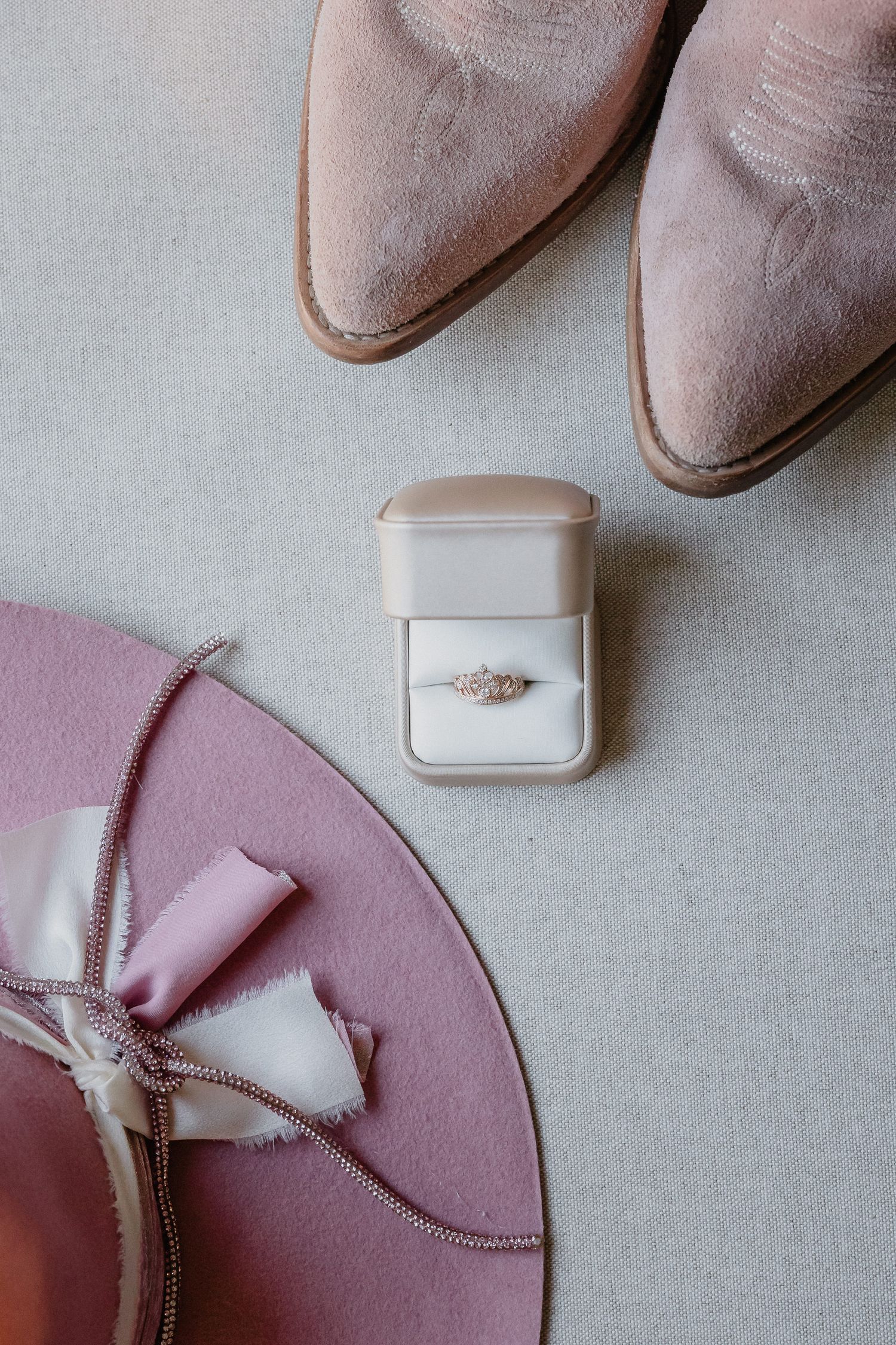 A series of close-up shots showing a diamond engagement ring in a white box against a pink and gray background.