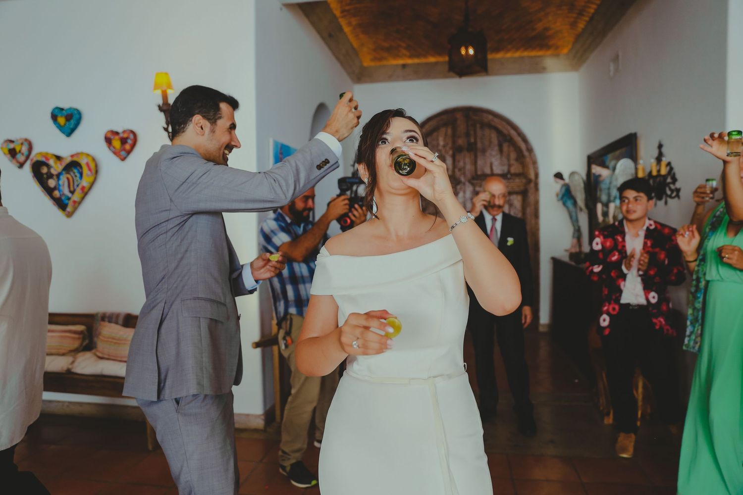 Couples dance together at a wedding reception with colorful heart decorations adorning the walls.Pedregal Los Cabos Wedding Photographer
