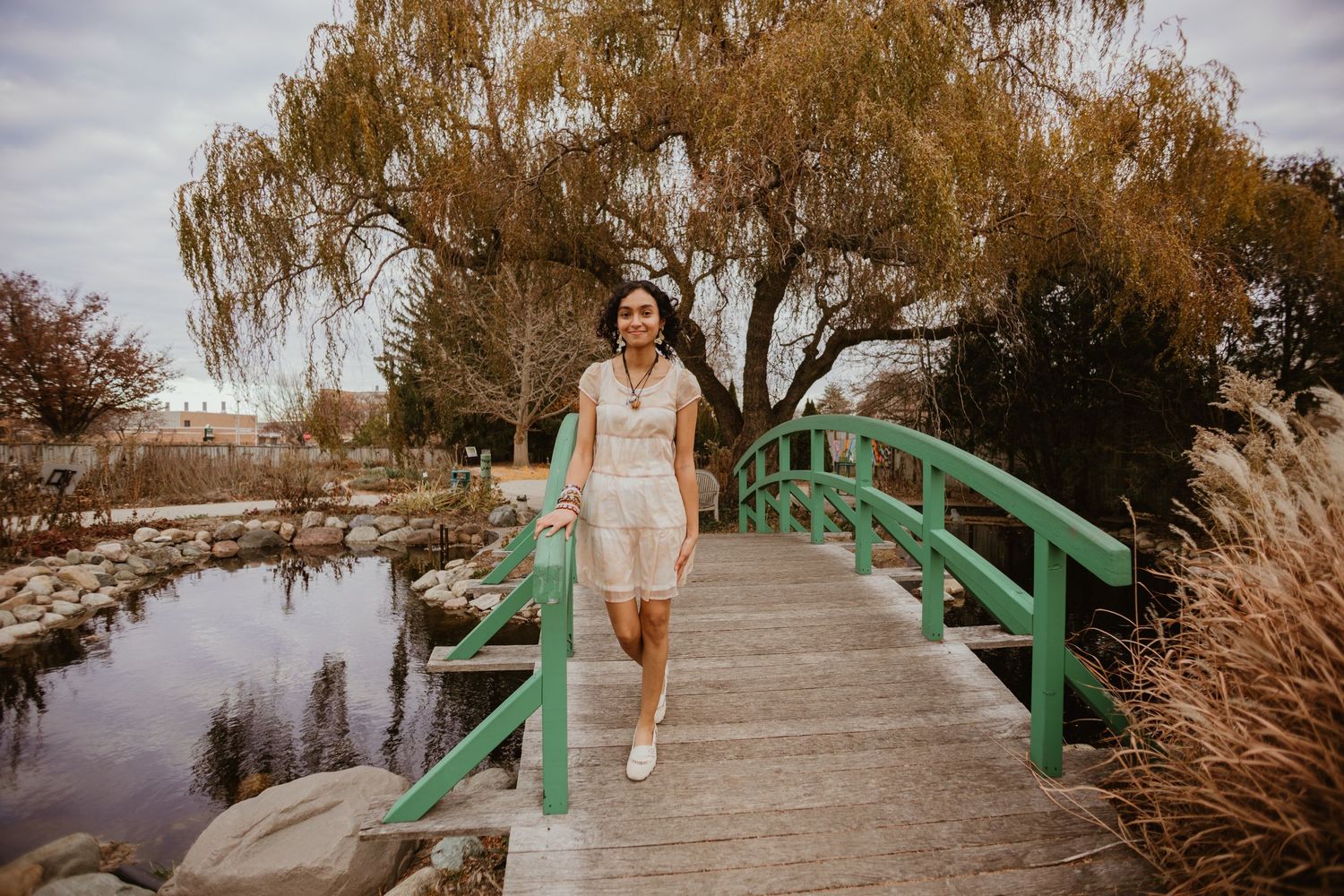 Multiple views of a wooden footbridge with green handrails crossing over water in a natural setting.