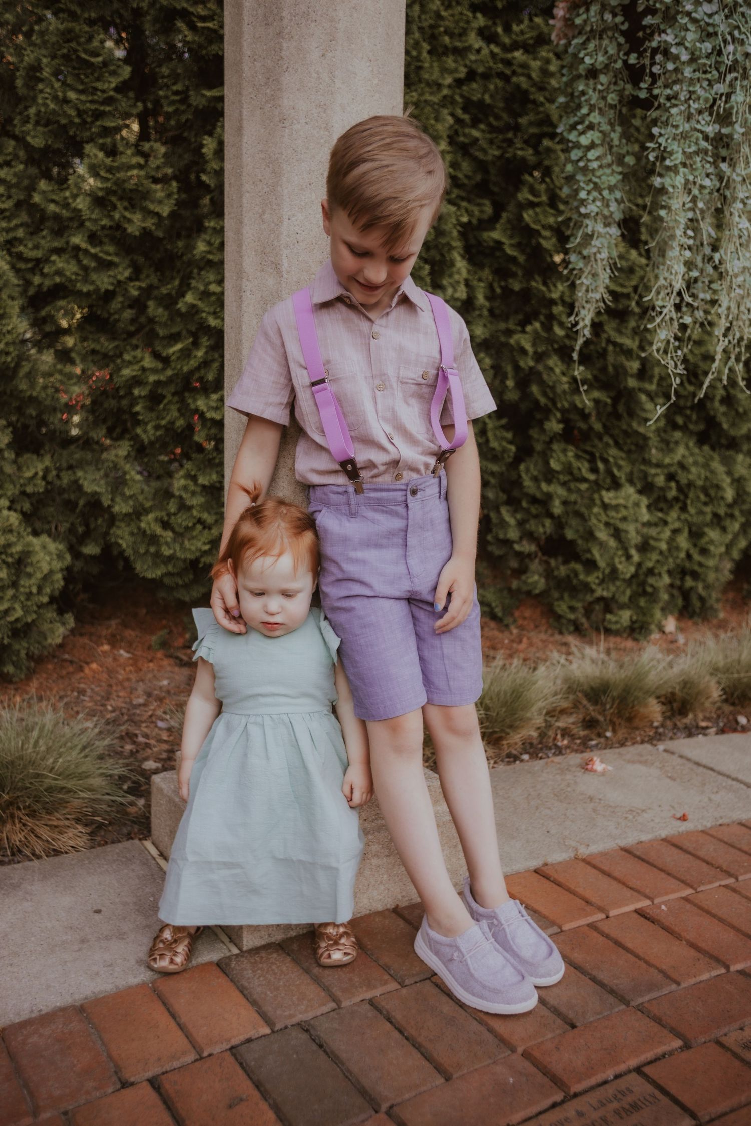A series of photos showing a child in a blue dress and someone in pink overalls walking on brick pavement.
