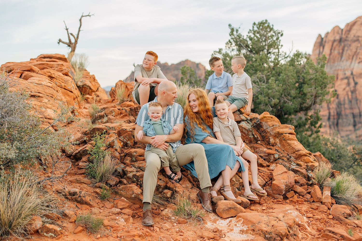 Group gathers on red sandstone formations in Snow Canyon State Park during golden hour.