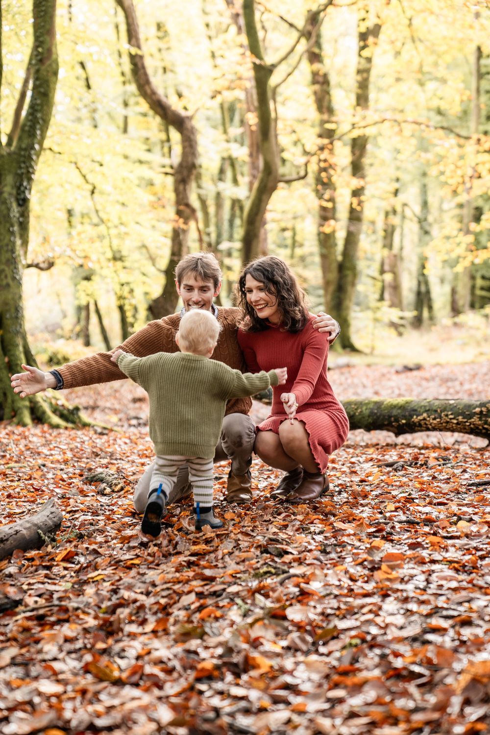 A joyful autumn scene in a forest with fallen leaves as people play together on a crisp fall day.