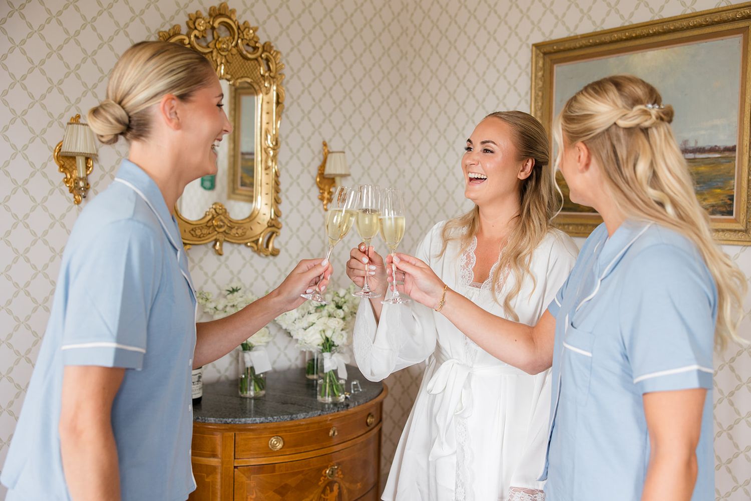 A couple in casual attire shares a romantic moment in an elegant room with ornate gold-framed mirrors.